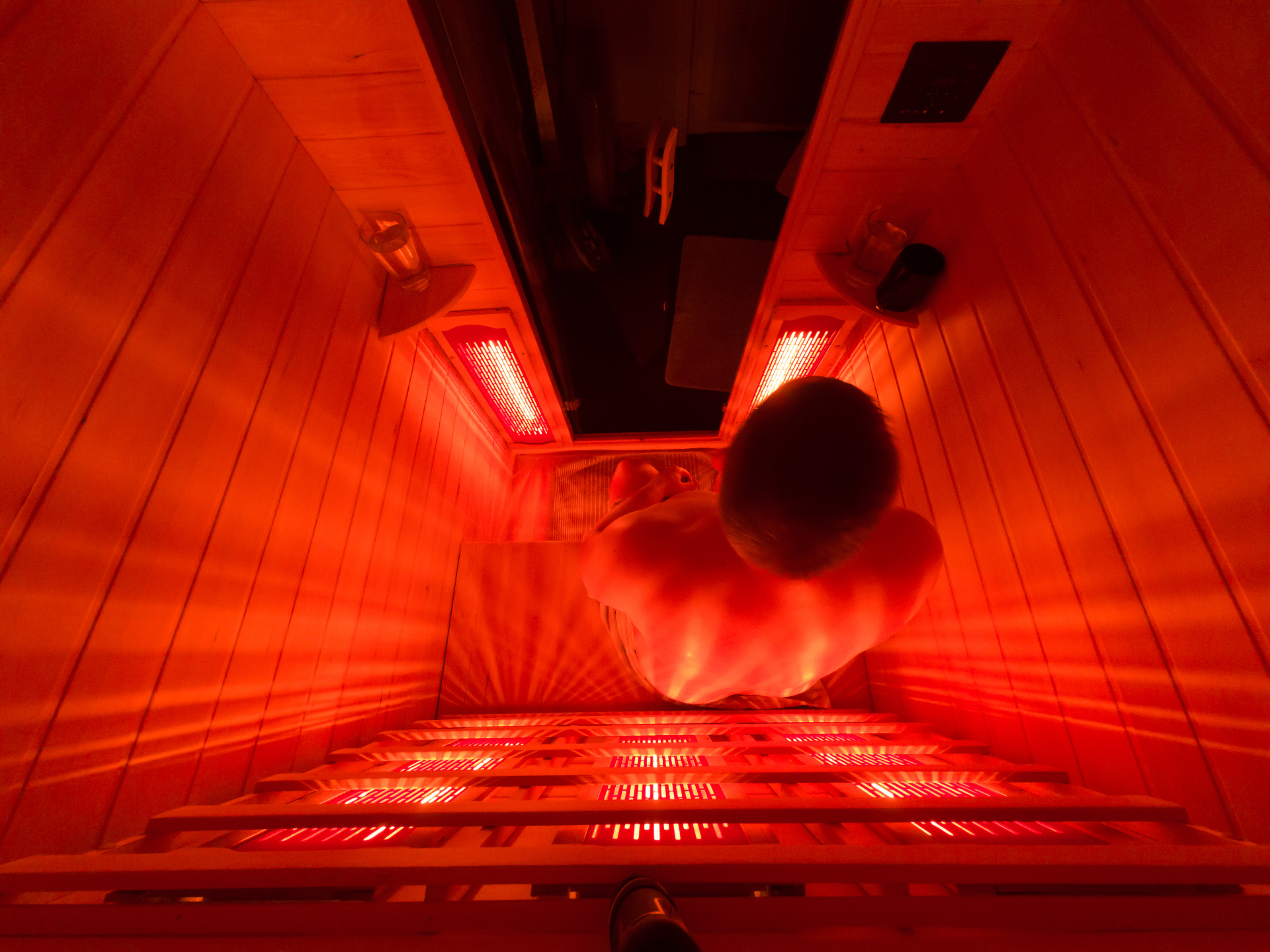 Overhead view of infrared sauna therapy session showing full-body infrared heat panels at REDSOL Wellness Club League City TX