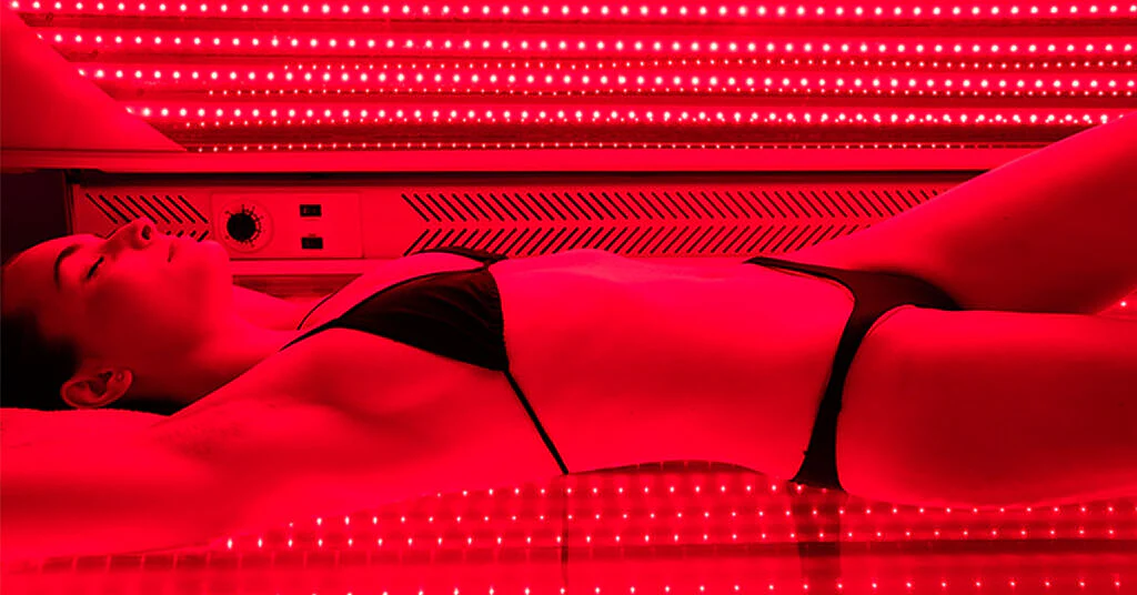 Woman relaxing during full-body red light therapy Pro-Bed session at REDSOL Wellness Club League City TX
