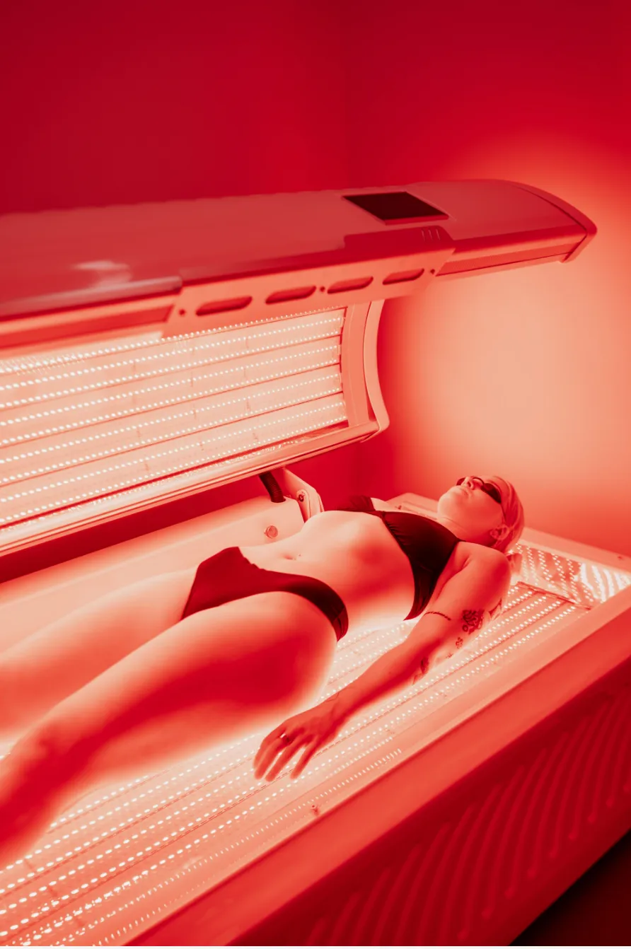 Woman receiving red light therapy session with therapeutic LED wavelengths at REDSOL Wellness Club League City TX